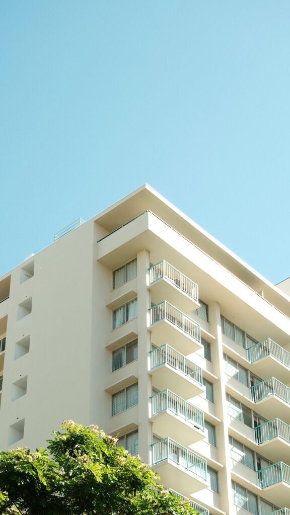 Minimalist view of a modern apartment building with a clear blue sky.
